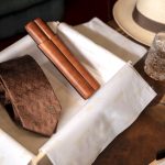 Miliari Cigars Limited Edition on a table with a glass of scotch and a leather cigars case